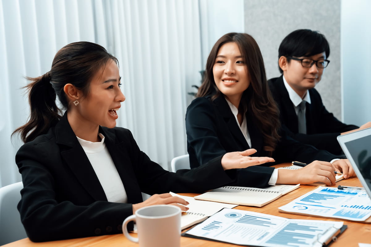 HR staff review training documents and charts at a meeting table.