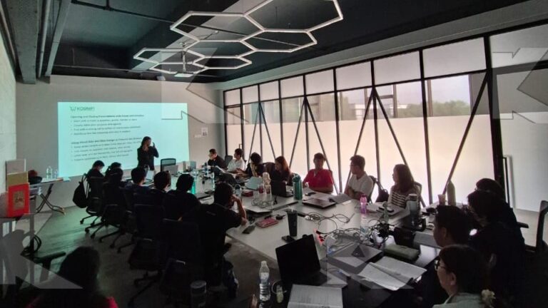 Participants follow the slides at long tables in a Kognifi Power of Business Communication Skills class