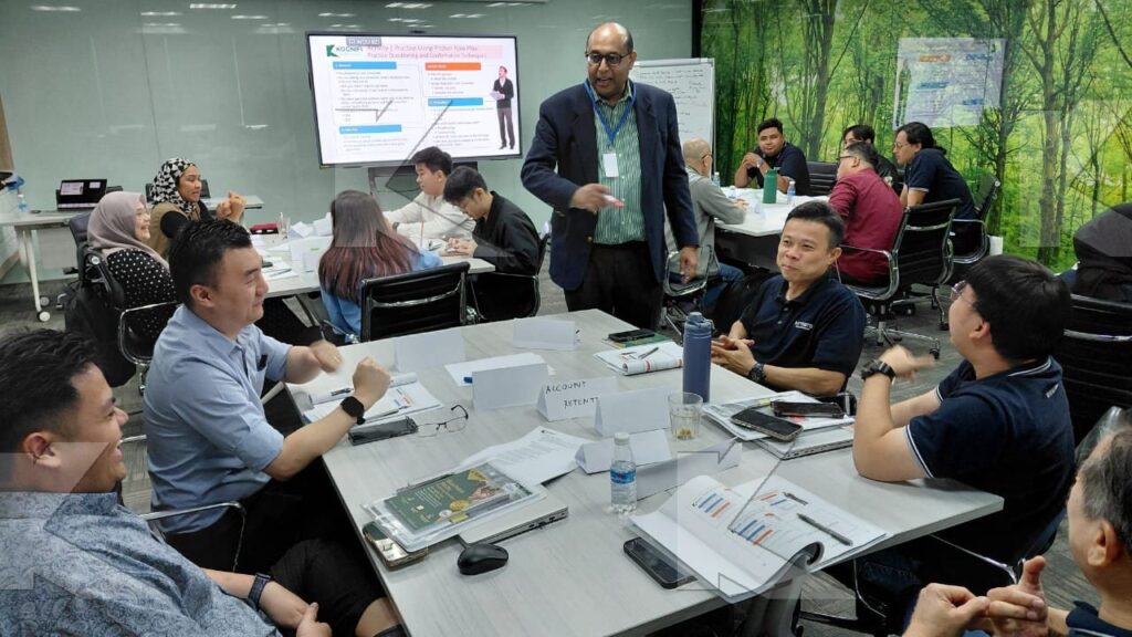 The trainer coaches a table in a Kognifi Business Communication, Negotiation and Data Visualization class
