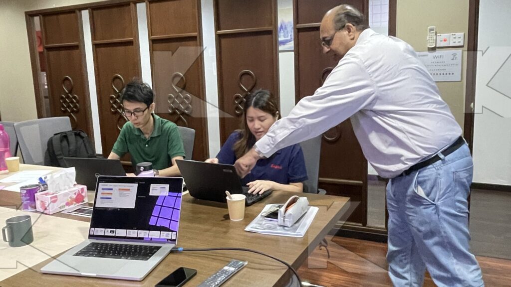 Trainer coaches a participant at a laptop in a Kognifi Digital Marketing class