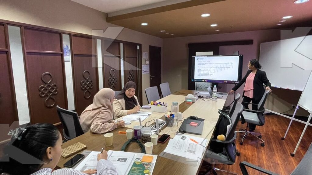Participants take notes while the trainer presents on screen in a Kognifi Governance and Ethics class