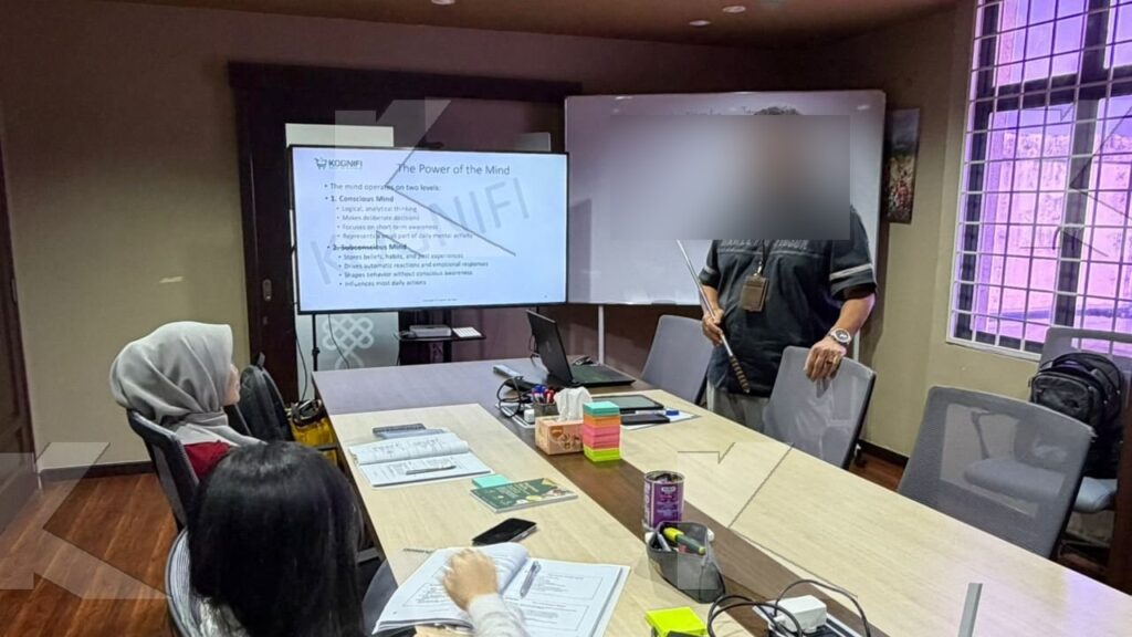 Participants work while the trainer explains on the whiteboard in a Kognifi Leadership Reimagined class