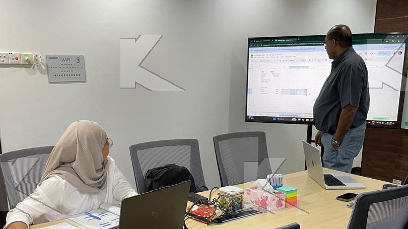 Participant works on a marketing plan while the trainer reviews the screen in a Kognifi Marketing Plan class
