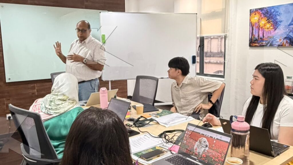 Trainer explains a copywriting point while participants work on laptops in a Kognifi SEO Copywriting class