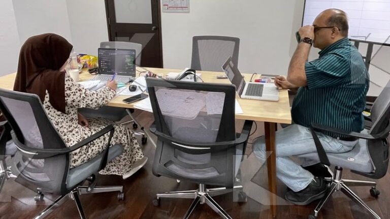 Trainer and a participant work on a tender evaluation at their laptops in a Kognifi Tender Bids Management class