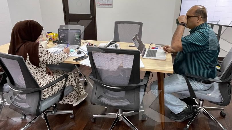 Trainer and a participant work on a tender evaluation at their laptops in a Kognifi Tender Bids Management class