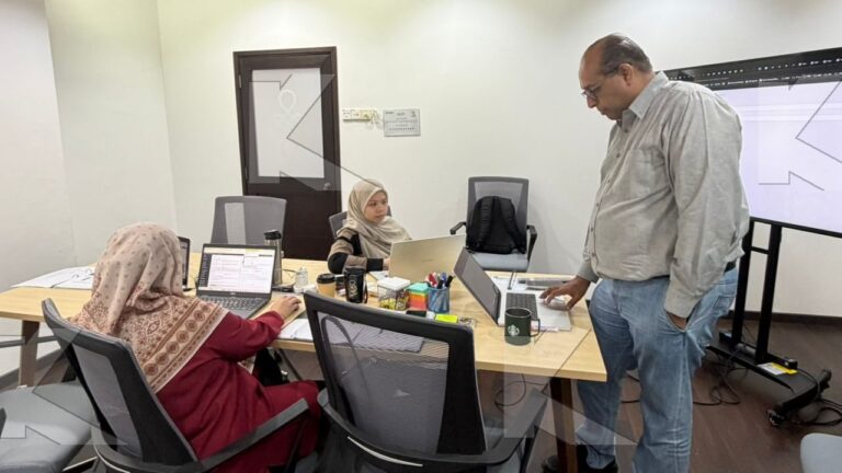 Participants build pages on their laptops while the trainer checks a setting in a Kognifi WordPress for Digital Marketing class